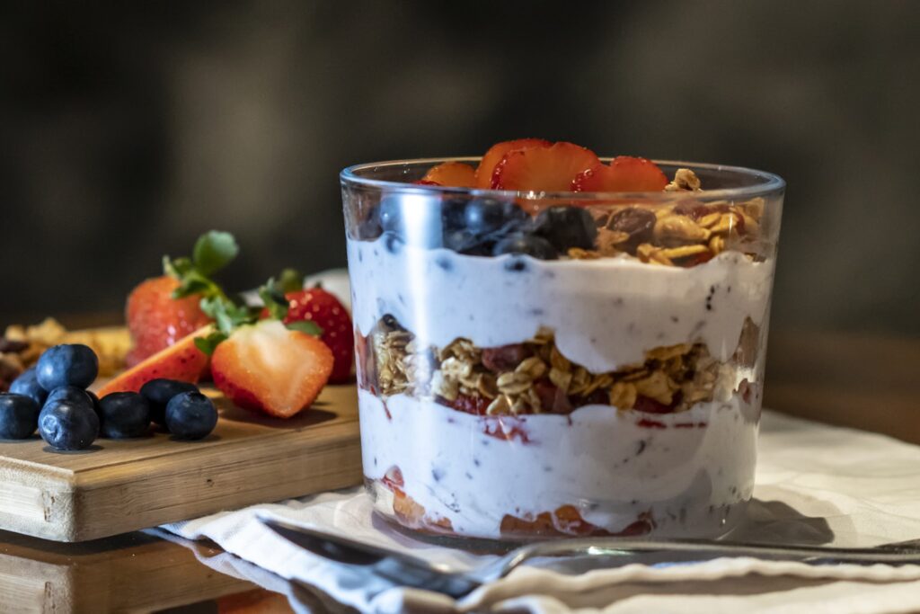 strawberries and cookies with cream filled dessert in glass cup
