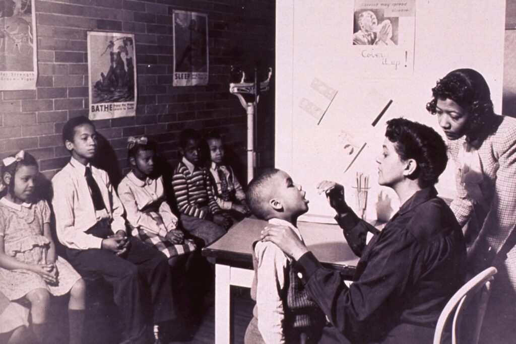 Throat exams Contributor(s): United States. Children's Bureau. Publication: [19--?] Format: Still image Subject(s): African America Genre(s): Pictorial Works Abstract: Interior view of a childrens' health clinic; an African American child is having his throat examined, other children are sitting against a wall awaiting their turns. Extent: 1 photographic print : 21 x 26 cm. Technique: black and white NLM Unique ID:101448734 NLM Image ID: A029845 Permanent Link: resource.nlm.nih.gov/101448734